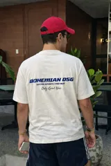 Remera blanca de algodón con estampado trasero en azul que dice "BOHEMIAN DSG CERTIFIED AUTHENTIC STREETWEAR Only Good News".