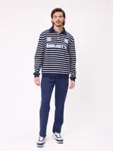 Babucha gris de algodón y poliéster, con cintura elástica, cordón ajustable y bolsillos laterales. Presenta el logo de Rusty bordado en el muslo izquierdo.