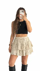 Pollera short beige con estampado de lunares pequeños, diseño de volados escalonados y cintura elástica.