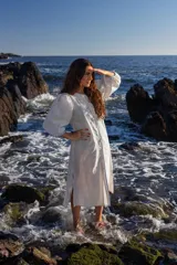 Vestido midi rayado con mangas abullonadas, botones frontales y aberturas laterales en el dobladillo.