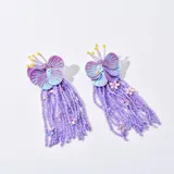 Aros colgantes con forma de flor de lentejuelas violetas y flecos de cuentas lilas.