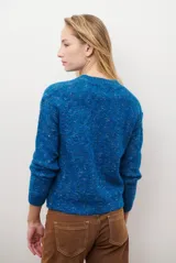 Cárdigan color crudo con textura jaspeada, cuello redondo y cierre frontal con botones.