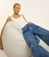 Pantalón estilo años 90 de tiro alto confeccionado en jean, con bolsillos cargo en los laterales y trabillas en la cintura.