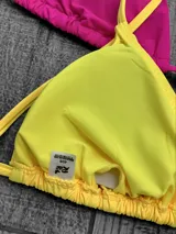 Corpiño de bikini tipo triángulo con copas removibles. Se ata en la espalda y tiene tiras ajustables que también permiten atarlo al cuello.