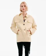 Chaqueta de corte recto color beige, con cuello camisero, cierre frontal de botones oscuros y cuatro bolsillos con solapa en el frente.