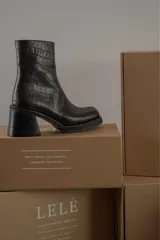 Bota de caña media con punta cuadrada, confeccionada en cuero gamuzado color marrón, con taco bloque y suela de goma negra.