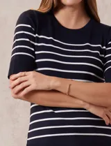 Buzo de punto fino Cable & Gauge, color negro con rayas horizontales blancas, manga corta y cuello redondo.