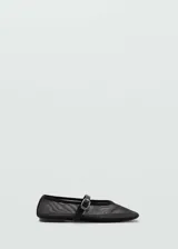Zapato tipo bailarina de malla negra con cierre de hebilla y cinta decorativa, de punta redonda y suela plana.