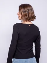 Top de manga larga ceñido al cuerpo, color negro, con escote bote pronunciado y detalle de botones forrados en el centro del pecho.