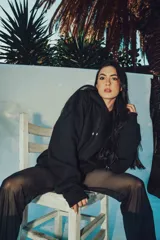 Hoodie blanco de corte oversize con capucha y diseño estampado en la espalda con letras negras.