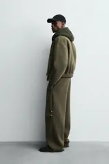 Cazadora de corte boxy fit confeccionada en tejido técnico compacto de algodón con elasticidad. Presenta cuello solapa, cierre frontal con cremallera, bolsillos de vivo en la cadera y acabados elásticos en puños y bajo.