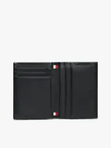 Billetera plegable Tommy Hilfiger confeccionada en piel negra con textura acanalada. Presenta un logo esmaltado distintivo de la marca en la parte frontal.