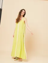 Vestido largo blanco de lino con escote en V y flecos de algodón en los bordes.