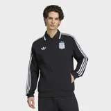 Campera deportiva Adidas de la selección argentina, color negro con diseño retro. Presenta cuello tipo polo con detalles en celeste y blanco, cierre frontal completo, las icónicas tres tiras blancas en las mangas, el logo del trifolio en el pecho derecho y el escudo de la AFA en el pecho izquierdo.