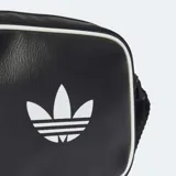 Bolso bandolera Adidas Adicolor Classic Airliner negro de cuero sintético con logo blanco. Tiene correa ajustable, compartimento principal con cierre y bolsillo frontal con cierre.