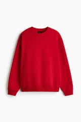 Buzo rojo de cuello redondo, con hombros caídos y remate acanalado en puños y bajo. Confeccionado en tejido de mezcla de algodón de peso medio con interior cepillado suave.