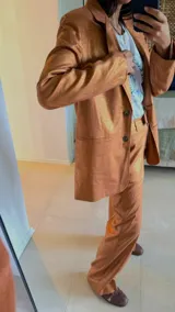 Blazer sastrero de corte recto y fit relajado, confeccionado en lino con hilos de lurex. Presenta solapas clásicas, hombreras, cierre frontal con un botón de nácar y bolsillos laterales con solapa.