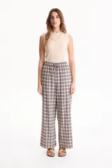 Pantalón ancho de lino con estampado en blanco y negro, cintura elástica con cordón de ajuste y bolsillos laterales.