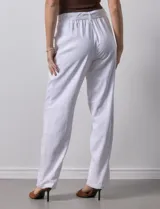 Pantalón blanco de lino con lazo en la cintura, corte recto y bolsillos laterales.