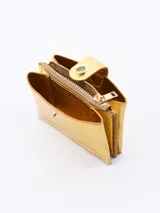 Billetera pequeña de diseño rectangular en color dorado con acabado texturizado. Cuenta con un cierre superior y una solapa frontal con broche a presión.