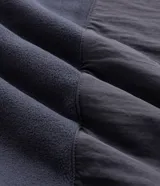 Buzo de fleece color verde agua con capucha ajustable, cierre frontal completo y bolsillo con cierre en el pecho. Presenta un diseño funcional con recortes en tejido plano y calce regular.