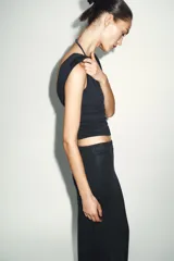 Top sin mangas color marrón topo, de corte ajustado, con cuello redondo y espalda descubierta.