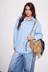 Camisa oversize de lino y viscosa color celeste, con cuello clásico, cierre frontal con botones y mangas largas.