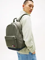 Mochila de diseño redondeado en color verde militar con base en azul marino. Cuenta con un compartimento principal con cierre de cremallera, un bolsillo frontal con cierre, asa superior y correas acolchadas ajustables. Incluye el parche distintivo de Tommy Jeans en la parte frontal.