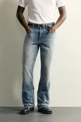Jeans flare fit de denim de algodón en color celeste con lavado efecto desgastado. Presentan diseño de cinco bolsillos, tiro medio, cierre frontal con cremallera y botón, y bajo con acabado irregular.