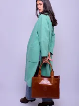 Cartera tipo tote de cuero color marrón, con doble asa de mano, compartimento interno removible y logo grabado en el frente.