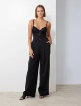 Pantalón palazzo de satén con tiro alto, pretina con pasadores, cierre y botón frontal, y elástico en la parte trasera. Cuenta con bolsillos laterales verticales.