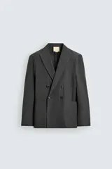 Blazer cruzado de corte relajado, confeccionado en mezcla de algodón y lino, en color gris oscuro. Presenta solapas de pico, bolsillos de parche en la cadera y cierre frontal de doble botonadura.