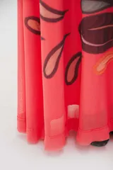 Vestido largo color coral con estampado de hojas en tonos violeta y marrón.