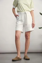 Short negro de tiro alto con lazo de tela para ajustar en la cintura y bolsillos laterales. El largo es por encima de la rodilla.