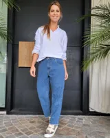 Pantalón de jean azul con corte recto, tiro medio y ruedo deshilachado.