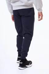 Pantalón de felpa con cintura elástica ajustable mediante cordón, bolsillos laterales y puños acanalados en los tobillos.