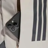 Mochila Adidas Apwr color beige con base y detalles en gris oscuro, con diseño funcional, correas ajustables y el logotipo clásico de la marca en el frente.