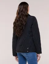 Campera matelaseada Michael Kors, de color beige con ribetes de ecocuero marrón. Cuenta con cuello con solapa, cierre frontal con broches metálicos, bolsillos laterales con cierre y mangas largas.