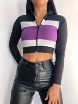 Top manga larga con cierre frontal y diseño tricolor con franjas horizontales en negro, blanco y rojo, fucsia, violeta o azul.