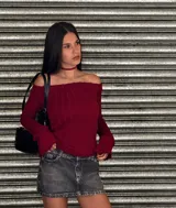 Sweater de punto trenzado color bordó, con escote tipo bardot (hombros descubiertos) y mangas largas acampanadas.