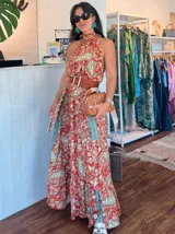 Vestido largo color salmón con estampado floral, cuello halter con volados y corte imperio.