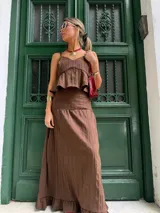 Falda larga marrón chocolate con textura plisada vertical y volado en el ruedo.