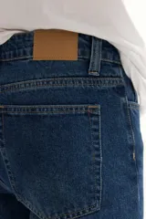 Jean de hombre, color gris oscuro con efecto lavado, corte recto y tiro medio.