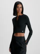 Sweater cárdigan de corte cropped y ajuste slim, confeccionado en tejido de punto canalé elástico. Presenta manga larga con abertura en los puños, cierre frontal con corchetes y el logo de Calvin Klein bordado en el bajo.