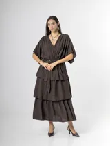 Vestido midi de crepé color marrón, con escote en V, mangas cortas amplias, cintura elastizada con lazo ajustable y falda larga escalonada con volados.