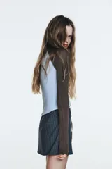 Falda pantalón (skort) de tiro medio, color azul grisáceo con finas rayas verticales blancas. Presenta un cinturón fino con hebilla metálica rectangular y cierre lateral oculto.