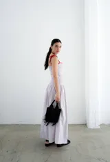 Vestido largo color crema con rayas verticales finas, fruncido en el busto y falda globo. Tiene detalles tejidos de crochet en breteles y escote.