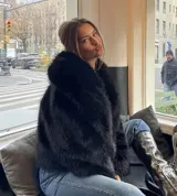 Chaqueta de piel sintética color negro, con cuello solapa amplio y diseño de pelo largo.