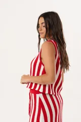 Chaleco tejido sin mangas con diseño de rayas verticales en color rojo y blanco. Presenta escote en V y cierre frontal con ganchitos ocultos.