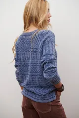 Buzo de tejido de punto en color azul con diseño geométrico texturizado, cuello redondo y mangas largas.